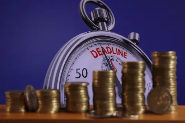 A stopwatch with "DEADLINE" highlighted and growing stacks of coins, suggesting that time is a factor in achieving financial mastery with GoMyFinance.com.